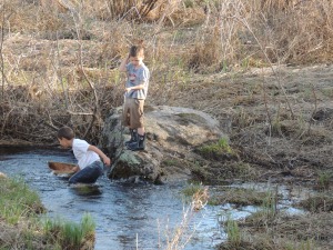 playing in the stream with their boat